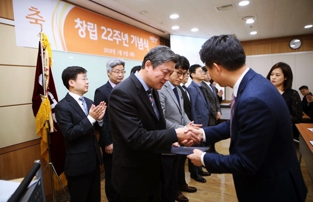 지난 8일 열린 창립 22주년 기념식에서 오스템 엄태관 대표가 직원들에게 상패를 전달하고 있다.