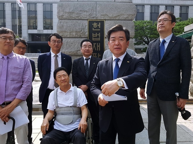 김철수 협회장이 합헌 편결 직후 헌법재판소 정문 앞에서 환영의 뜻을 담은 입장문을 발표하고 있다. 좌측엔 김세영 전 회장과 이상훈 특위 위원장.