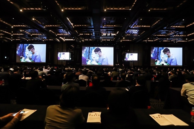 그랜드볼룸을 가득 채운 SID 2019 참가자들이 김현종 원장의 라이브 서저리를 영상으로 참관하고 있다.
