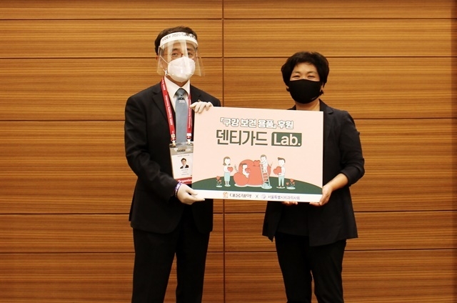 지난 6일 진행된 구강보건의 날 기념식에서 김민겸 회장이 서울시 지역아동센터 지원단 박영선 단장에게 구강용품 세트를 전달하고 있다.