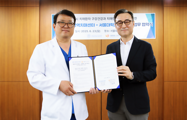 서울대치과병원 명훈 진료처장(왼쪽)과 서울시 광역치매센터 이동영 센터장이 협약서를 들어보이고 있다.