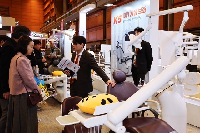 지난 1월의 DENTEX 2025 전시장에서 한 참가자가 부스 담당자에게 제품에 관한 설명을 듣고 있다.