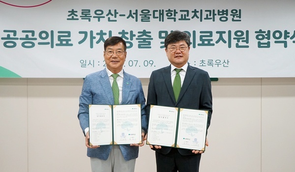 서울대치과병원 이용무 원장(오른쪽)과 초록우산 황영기 회장이 협약서를 들어보이고 있다.